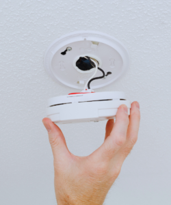 Electrician installing long lasting smoke detector